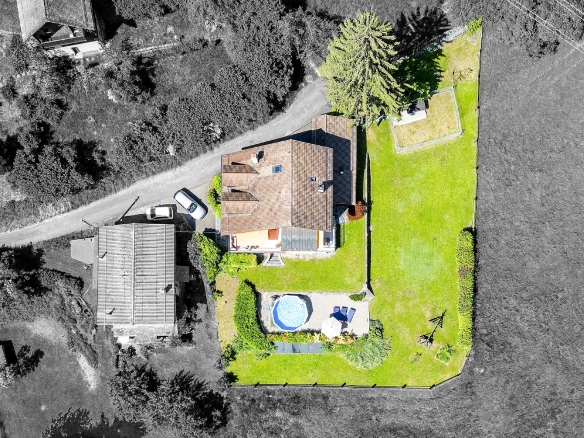 Vue aérienne de la maison familiale avec piscine et jardin à Blonay.