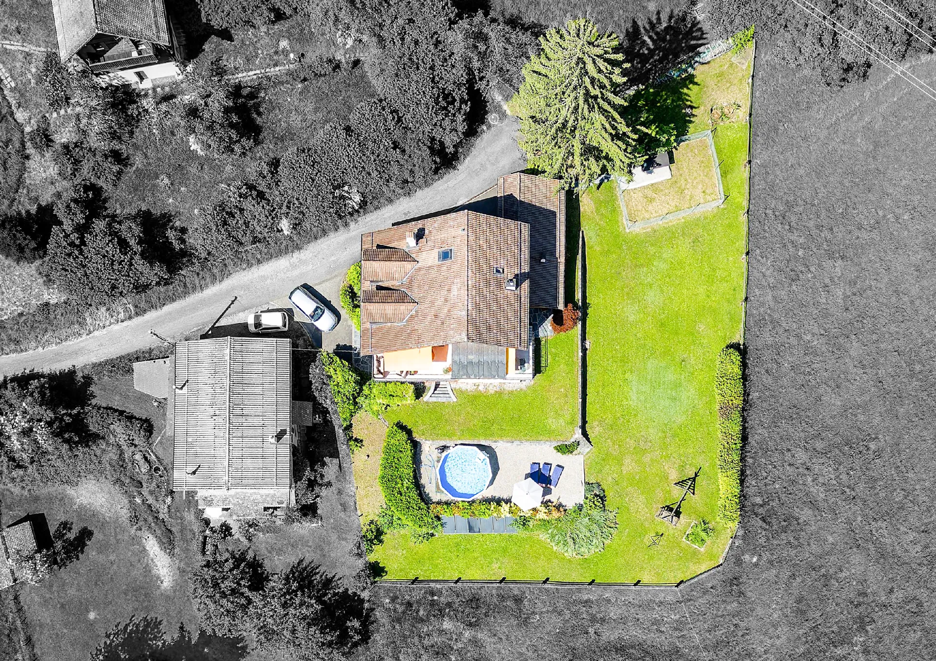 Vue aérienne de la maison familiale avec piscine et jardin à Blonay.