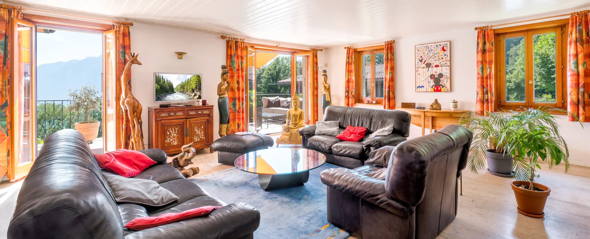 Salon lumineux avec cheminée et grandes fenêtres à Blonay.