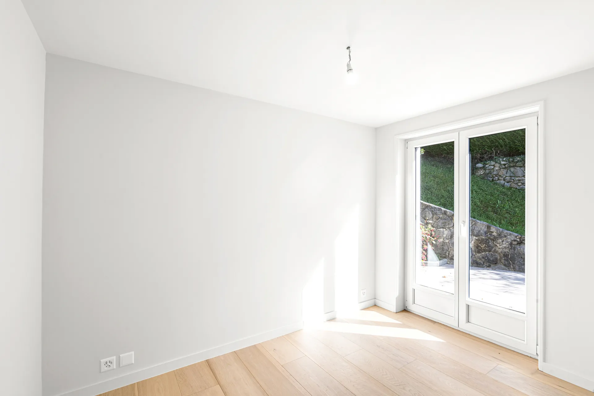 Chambre donnant sur le jardin avec porte-fenêtre