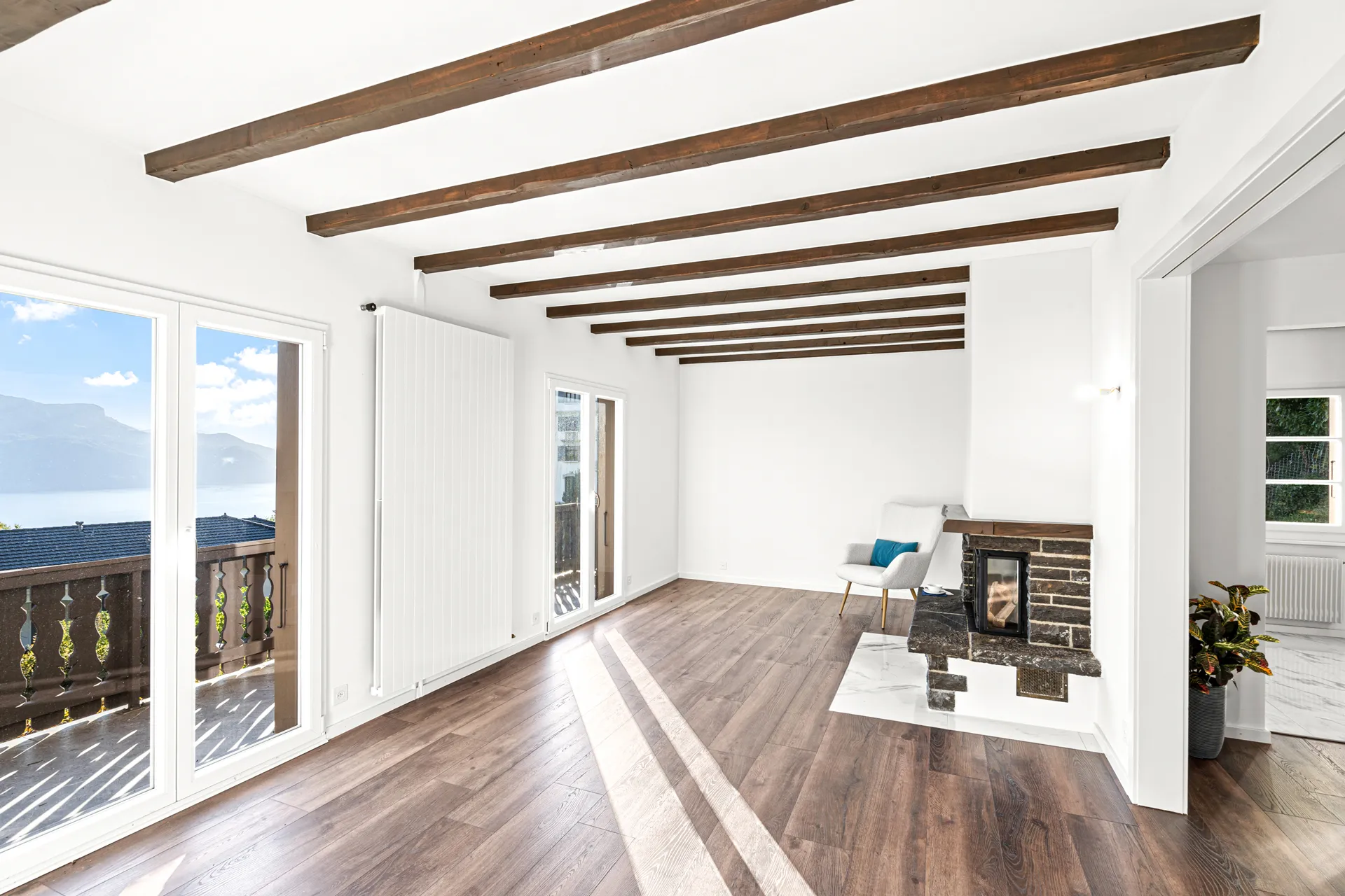 Grand séjour avec poutres apparentes, parquet et cheminée à Chernex