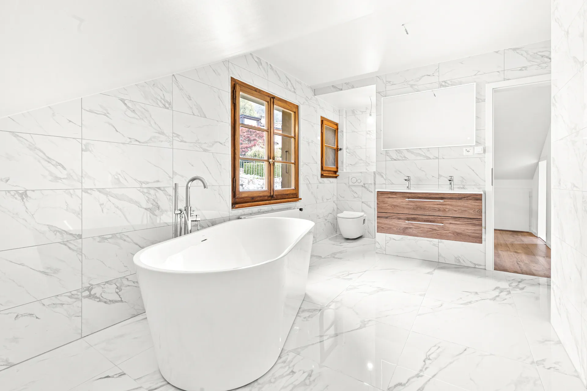 Salle de bain moderne avec baignoire design et vue sur l’extérieur à Chernex