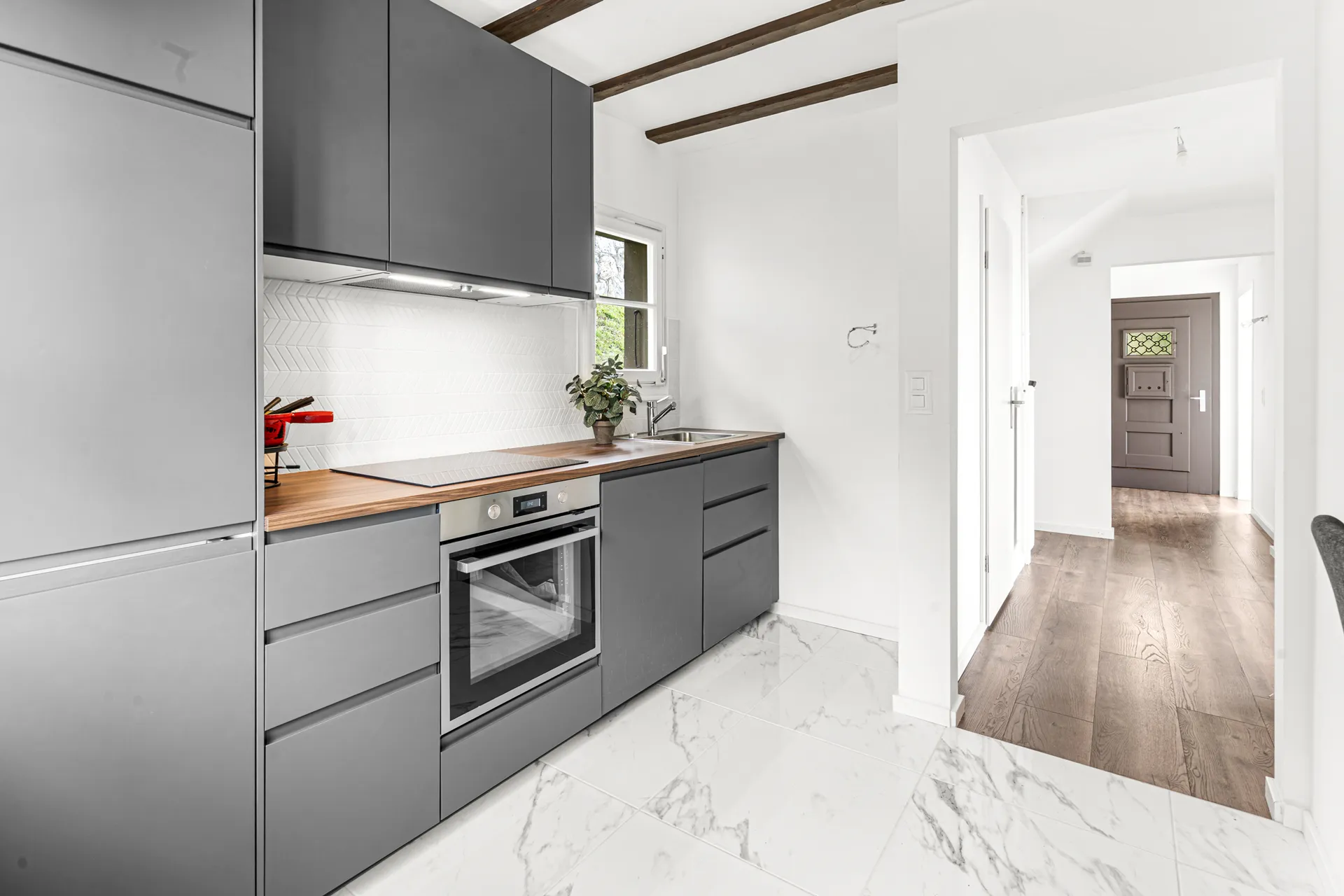 Cuisine ouverte avec armoires grises et plan de travail en bois