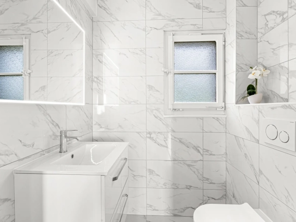 Salle de bain lumineuse avec finitions marbre et grande vasque