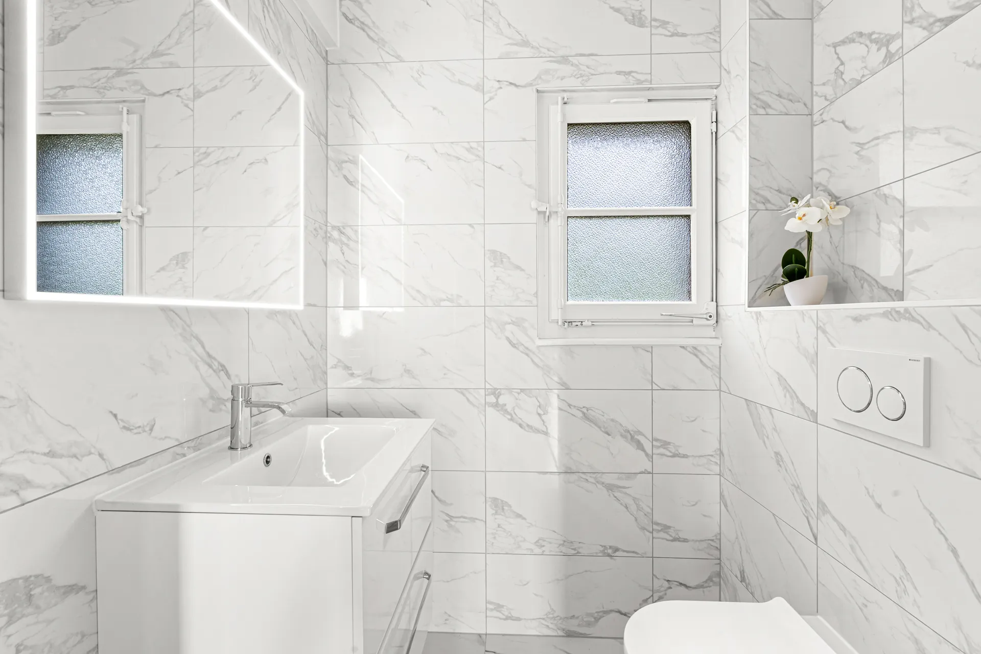 Salle de bain lumineuse avec finitions marbre et grande vasque