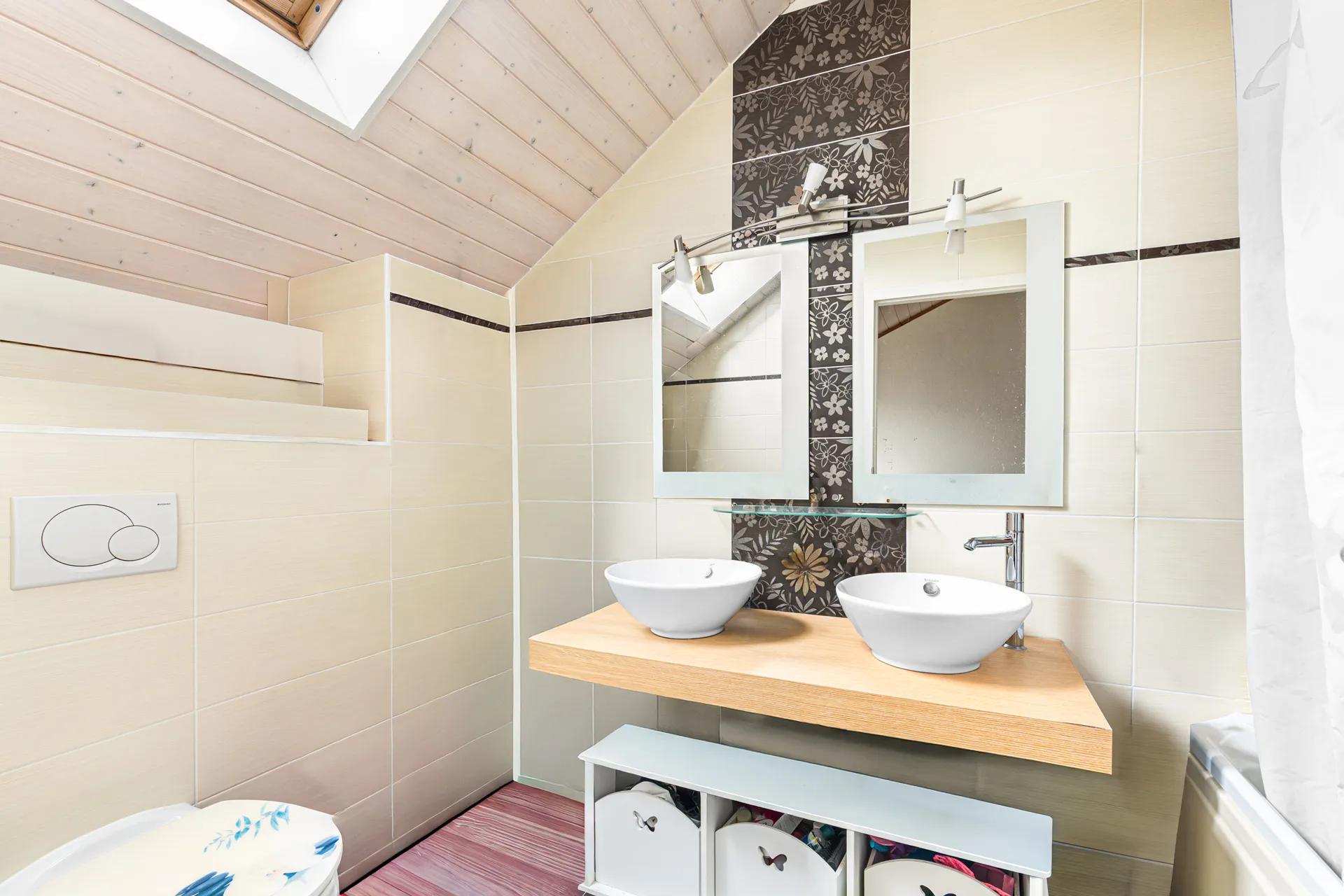 Salle de bain moderne sous combles avec double vasque et douche italienne.