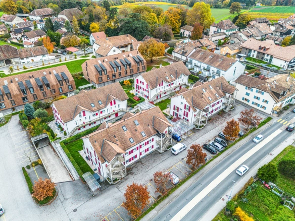 Vue aérienne d'un quartier résidentiel calme entouré d'arbres et de maisons mitoyennes.