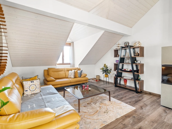 Petit espace détente avec fauteuil, baies vitrées et vue sur le lac Léman.