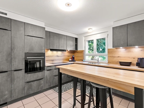 Cuisine moderne équipée avec îlot dans maison à Villeneuve