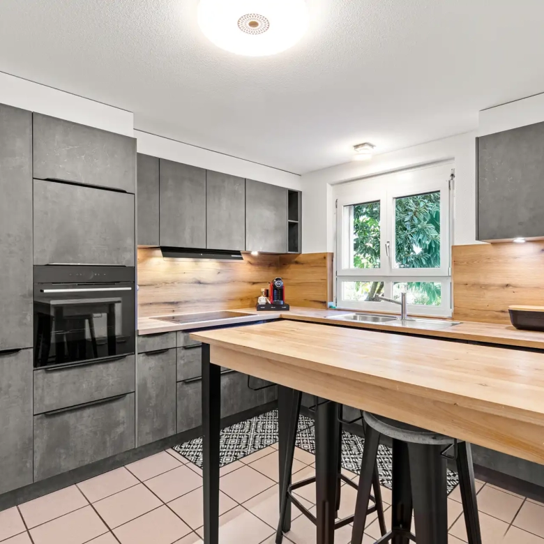 Cuisine moderne équipée avec îlot dans maison à Villeneuve